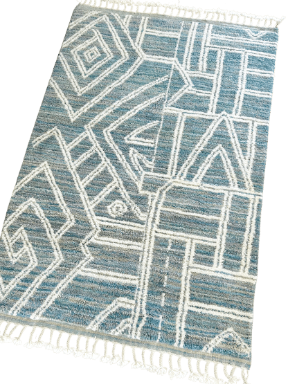 Full shot of a Moroccan rug with white line designs on a mixed blue background.