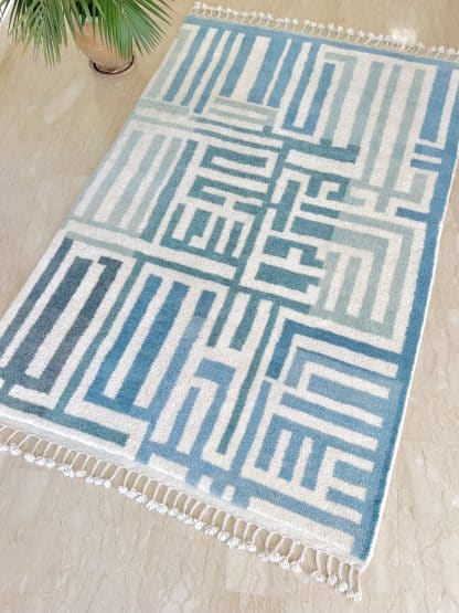 Beni Ourain Moroccan Rug with a blue and white maze design on a marble floor.