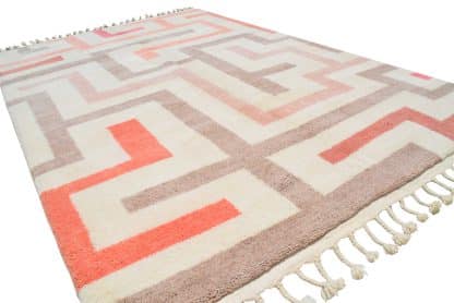 Angled, full shot of a Beni Ourain Moroccan Rug with a bold cream, beige and pink maze design.