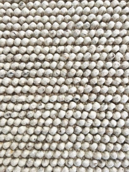 Close up shot of a Handmade Moroccan rug Tapis de Boules in beige