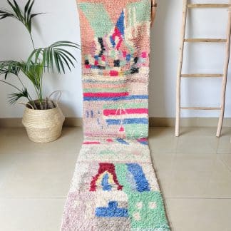 Woman holding a Moroccan rug, Azilal Runner - Tropical. A hand-knotted, runner rug with a unique, colourful design.