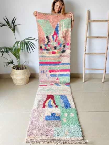 Woman holding a Moroccan rug, Azilal Runner - Tropical. A hand-knotted, runner rug with a unique, colourful design.
