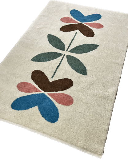 Full shot of a hand-knotted Beni Ourain style rug created with White Otter Design Co. It features a cream base with a large floral design in green, red, pink and yellow.